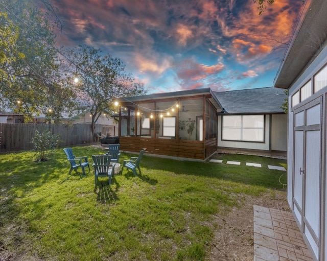 back house at dusk featuring a yard