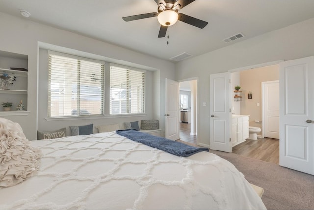 bedroom featuring ceiling fan, ensuite bathroom, and light wood-type flooring