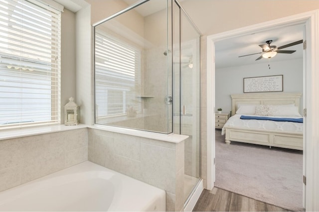 bathroom with a tub, ceiling fan, and hardwood / wood-style floors