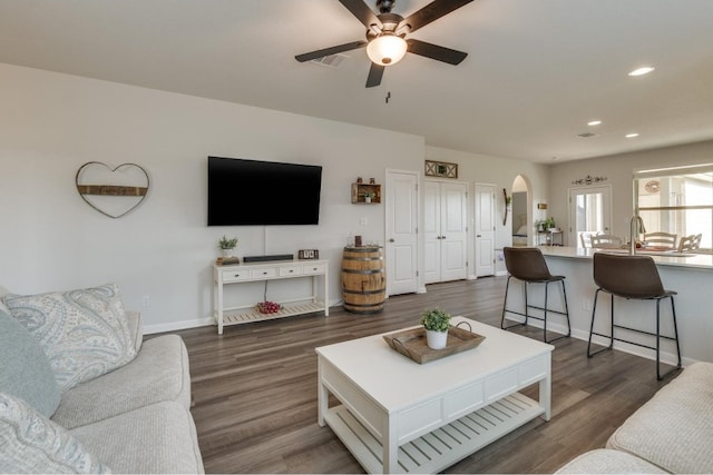 living room featuring ceiling fan, dark hardwood / wood-style flooring, and sink