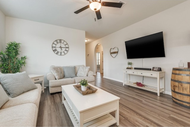 living room featuring ceiling fan and dark hardwood / wood-style floors