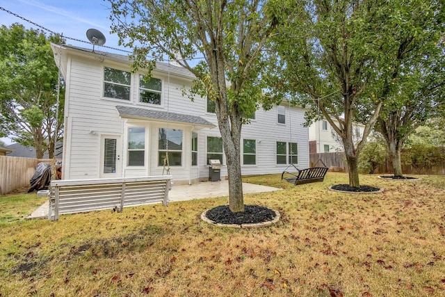 rear view of house with a lawn and a patio area