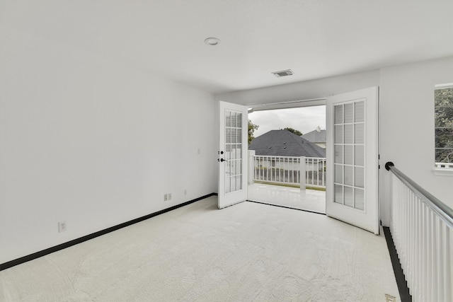 unfurnished room with light carpet and french doors