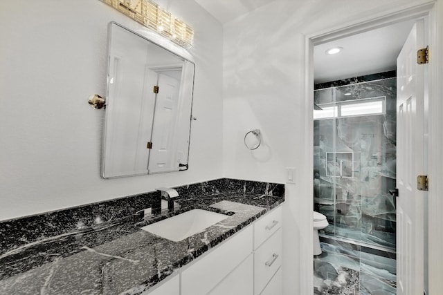 bathroom with toilet, vanity, and an enclosed shower