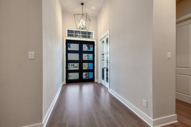 entrance foyer featuring hardwood / wood-style flooring, french doors, and a notable chandelier