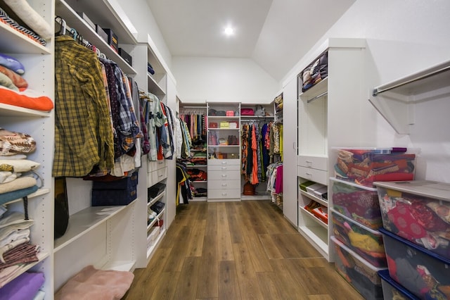 walk in closet with vaulted ceiling and dark hardwood / wood-style flooring