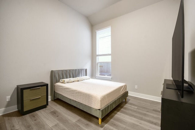 bedroom featuring lofted ceiling and light hardwood / wood-style flooring