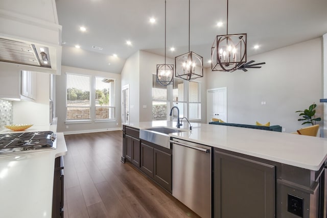 kitchen with dark hardwood / wood-style flooring, a center island with sink, sink, stainless steel dishwasher, and decorative light fixtures