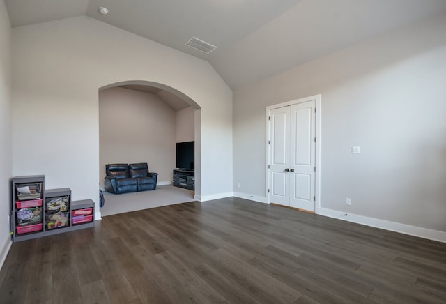 empty room featuring dark wood-type flooring and vaulted ceiling