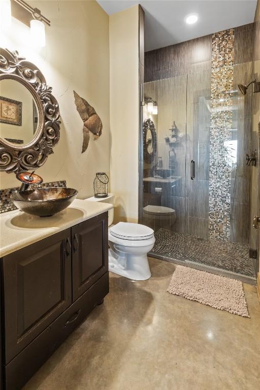 full bathroom featuring vanity, a shower stall, and toilet