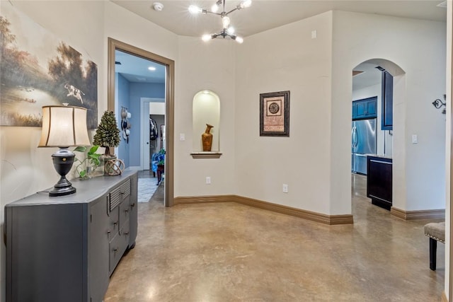 4609 Boxwood Bnd, Lago Vista, TX 78645 - hallway featuring concrete flooring, arched walkways, and a chandelier