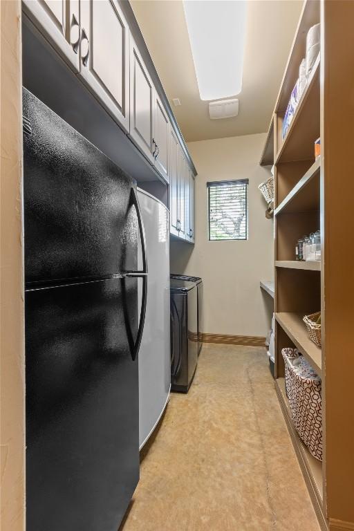 laundry room with cabinet space, baseboards, and separate washer and dryer