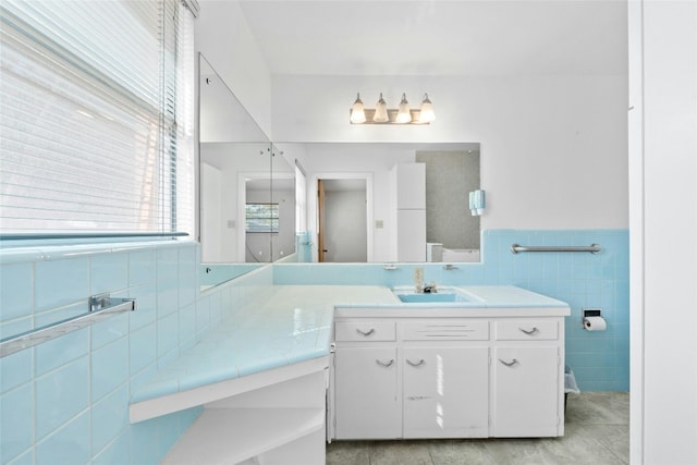 1311 Ridgehaven Dr, Austin, TX 78723 - bathroom featuring tile walls, tile patterned floors, vanity, and wainscoting