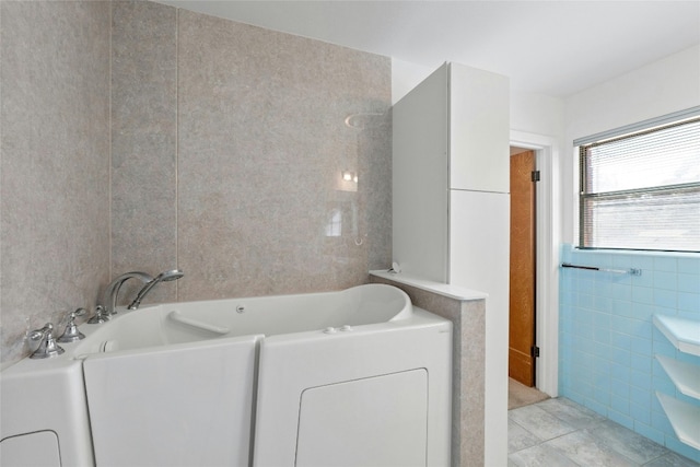 bathroom featuring tile walls, a bath, and tile patterned floors