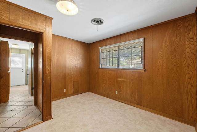 unfurnished room featuring light colored carpet and wood walls