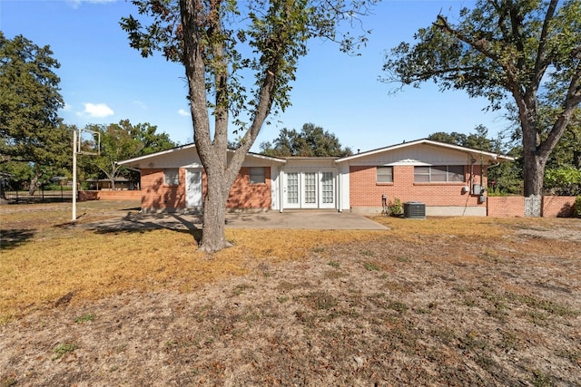 back of house with a lawn, central AC, a patio, and french doors