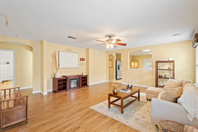 living room featuring ceiling fan and light hardwood / wood-style flooring