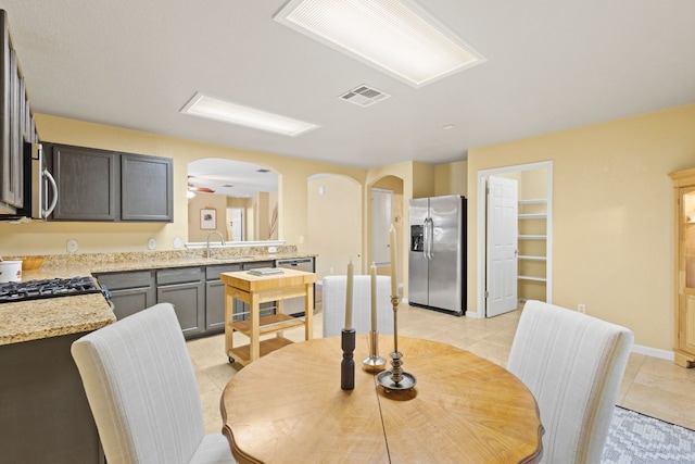 tiled dining area featuring ceiling fan and sink