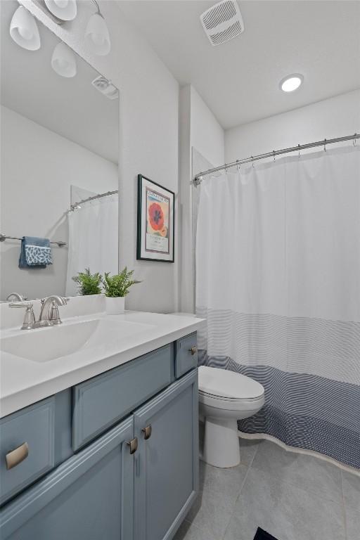 bathroom with tile patterned flooring, vanity, and toilet