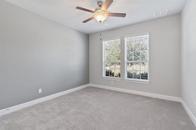 carpeted spare room with ceiling fan