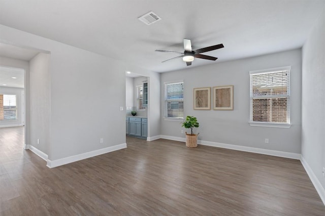 unfurnished living room featuring ceiling fan and dark hardwood / wood-style floors