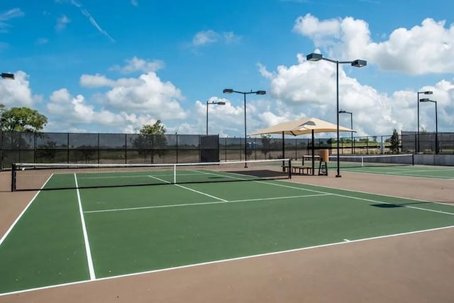 view of tennis court featuring basketball hoop