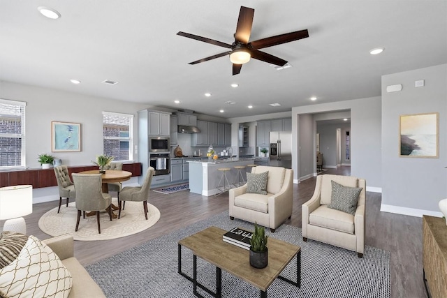 living room with ceiling fan, sink, and hardwood / wood-style flooring