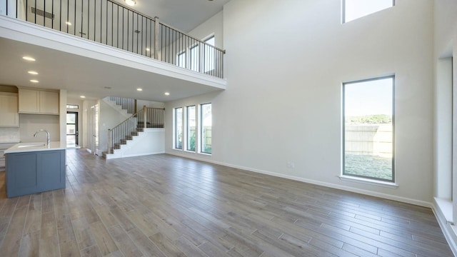 unfurnished living room featuring a high ceiling and sink