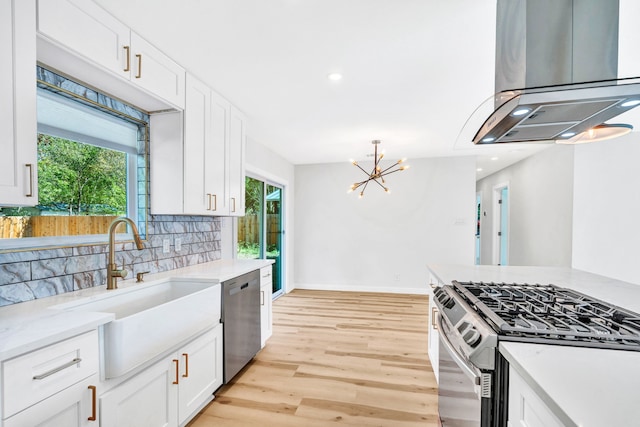 kitchen featuring stainless steel appliances, white cabinets, and island exhaust hood