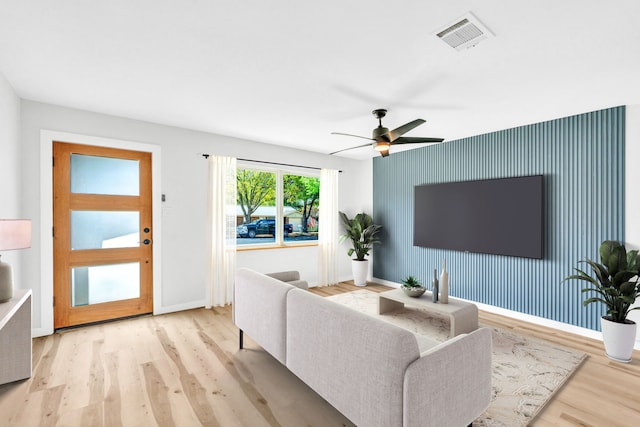 living room with ceiling fan and light hardwood / wood-style flooring