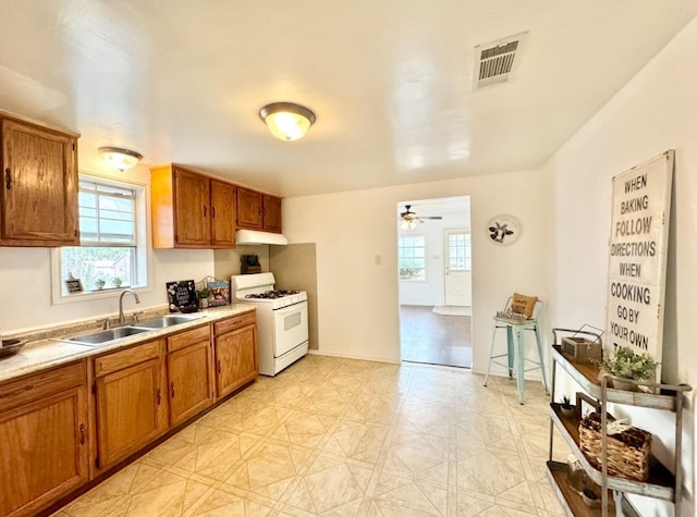 kitchen featuring sink, gas range gas stove, and ceiling fan