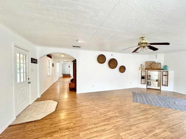 unfurnished living room featuring ceiling fan, a textured ceiling, and light hardwood / wood-style floors