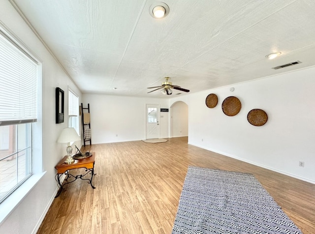 living room with a textured ceiling, light hardwood / wood-style floors, a healthy amount of sunlight, and ceiling fan