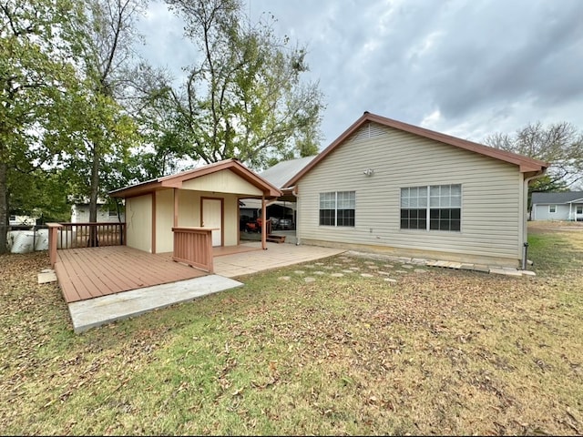 rear view of property with a deck, a lawn, and a patio area