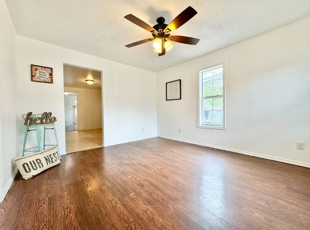 unfurnished room with dark hardwood / wood-style flooring, a textured ceiling, and ceiling fan