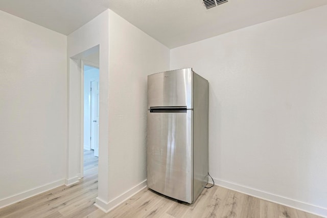 kitchen featuring stainless steel fridge and light hardwood / wood-style floors