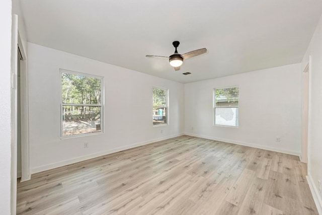 empty room featuring light wood-type flooring, a wealth of natural light, and ceiling fan