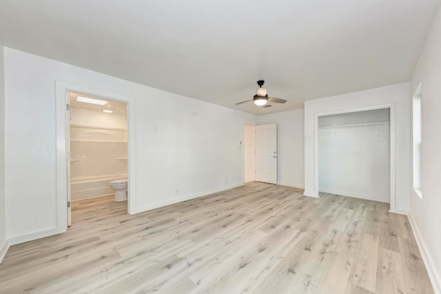 unfurnished bedroom featuring a closet, light hardwood / wood-style floors, ceiling fan, and ensuite bathroom