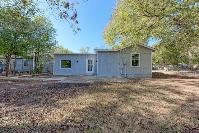 rear view of property featuring a patio area and a lawn