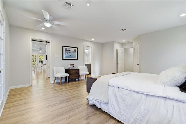 bedroom featuring light hardwood / wood-style floors, ceiling fan, and ensuite bathroom