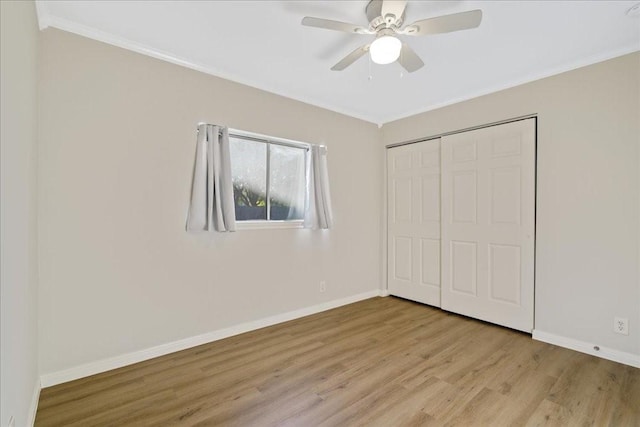 unfurnished bedroom featuring crown molding, light hardwood / wood-style floors, and a closet