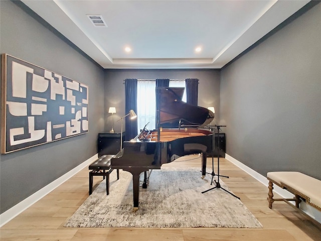 miscellaneous room featuring light hardwood / wood-style floors and a raised ceiling