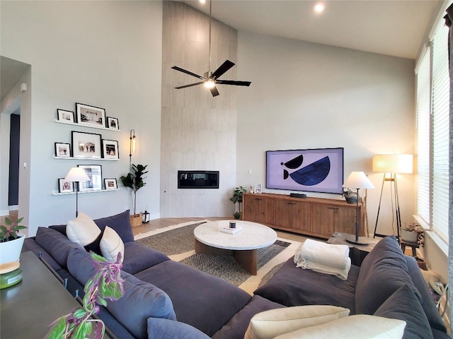 living room featuring high vaulted ceiling, ceiling fan, and a fireplace