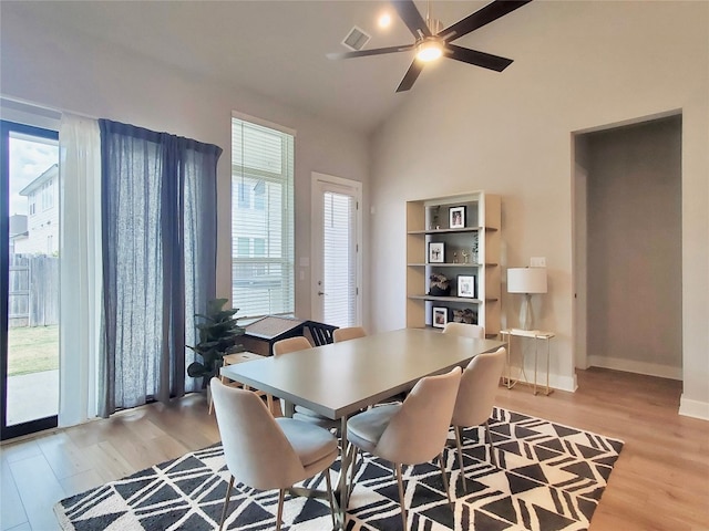 dining space featuring light wood-type flooring, vaulted ceiling, and ceiling fan