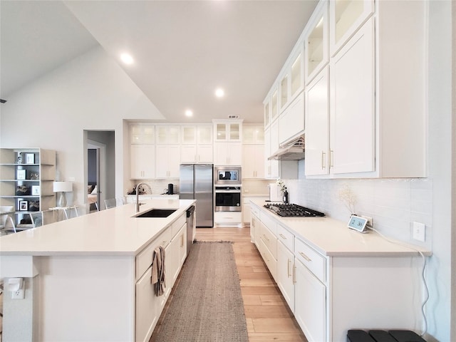 kitchen featuring stainless steel appliances, a breakfast bar area, white cabinets, and sink