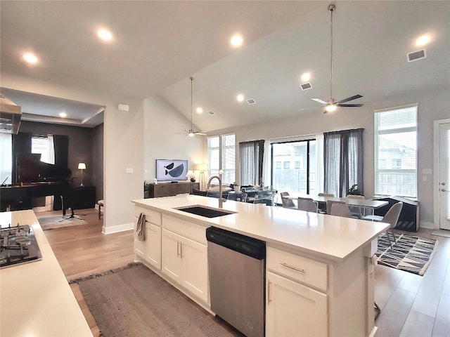 kitchen with white cabinetry, sink, vaulted ceiling, an island with sink, and dishwasher