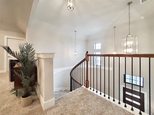 stairs featuring carpet flooring and a chandelier