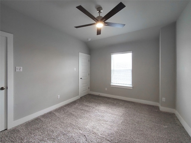 carpeted spare room featuring lofted ceiling and ceiling fan