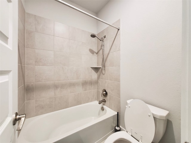 bathroom featuring tiled shower / bath and toilet