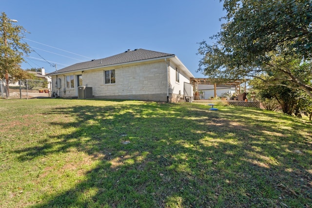 rear view of property featuring cooling unit, a pergola, and a yard